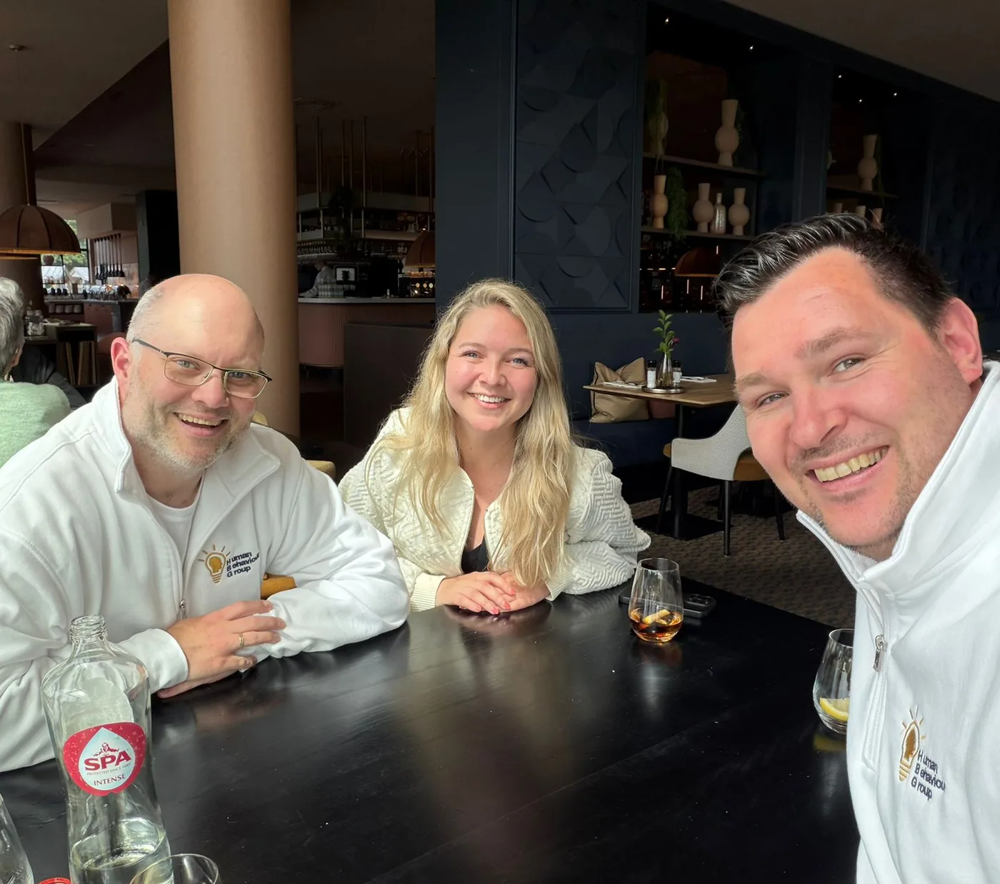 Theo, Lisa en Peter van Human Behaviour Group in gesprek aan tafel